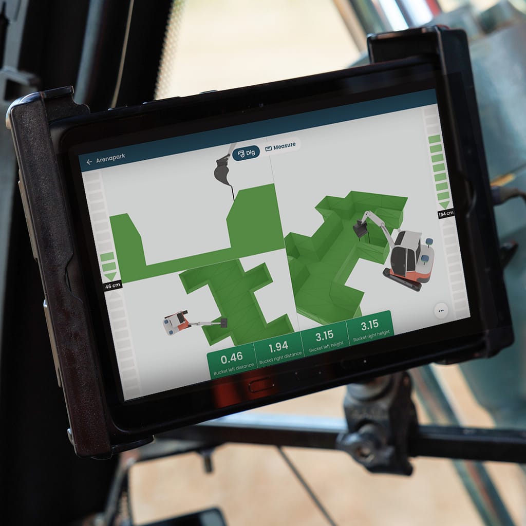 Gebruiksvriendelijke machinebediening, Tabletscherm dat een 3D graafbesturingssysteem weergeeft met meerdere weergaven van een graafmachine die een sleuf graaft en de positionering van de bak en afstandsmetingen toont. De interface bevat realtime diepte-indicatoren en opties voor meten en graven.