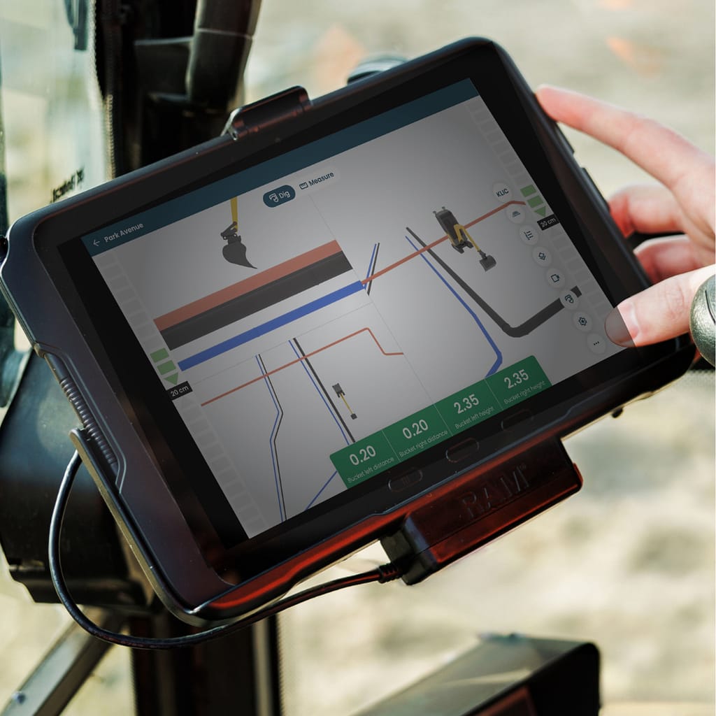 Tabletscherm met een 3D-besturingssysteem voor graafwerkzaamheden met meerdere weergaven van een graafmachine die een sleuf graaft, met bak, om graafschade te voorkomen.